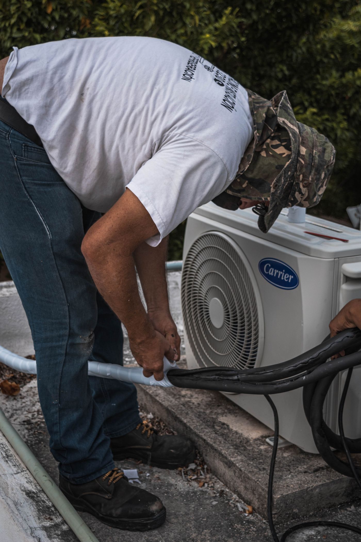 Technician performing emergency AC repair on an outdoor unit